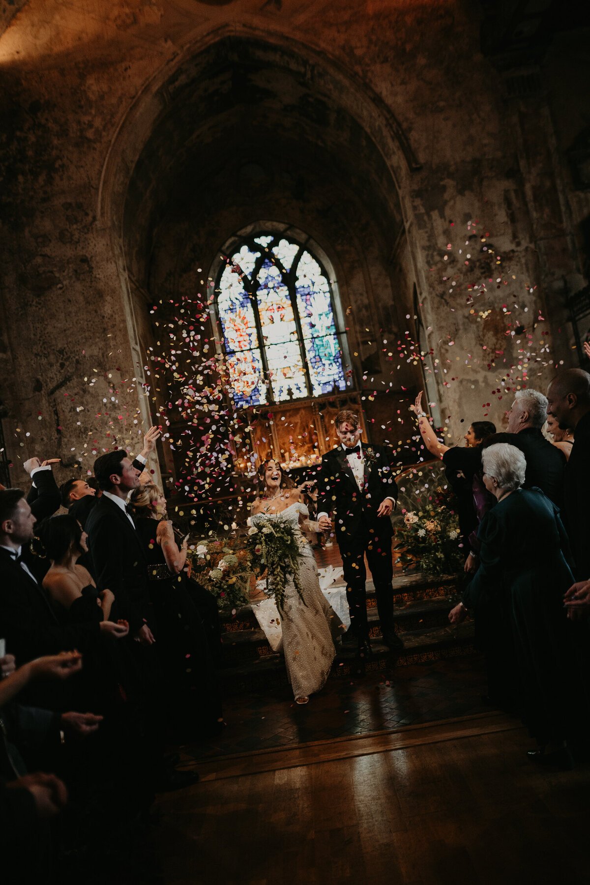 A bride and groom come back up the aisle at The Mount Without in Bristol as their wedding guests throw confetti. 