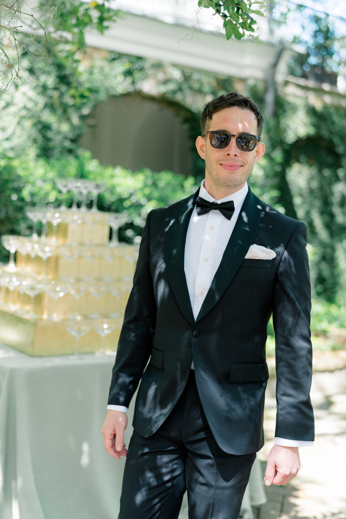 Candid photo of the groom on wedding day. Groom in sunglasses and tuxedo