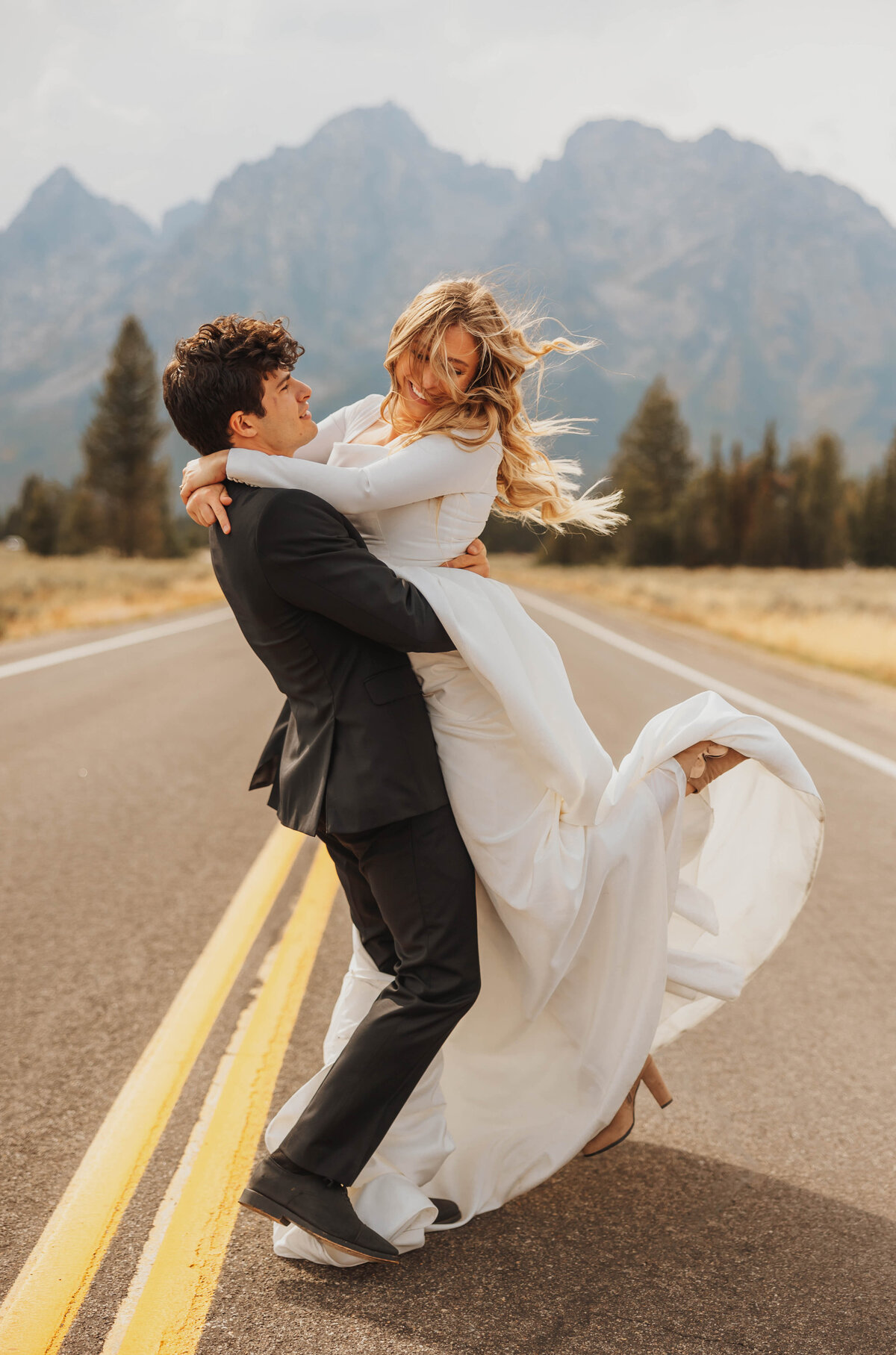bride and groom embracing in road