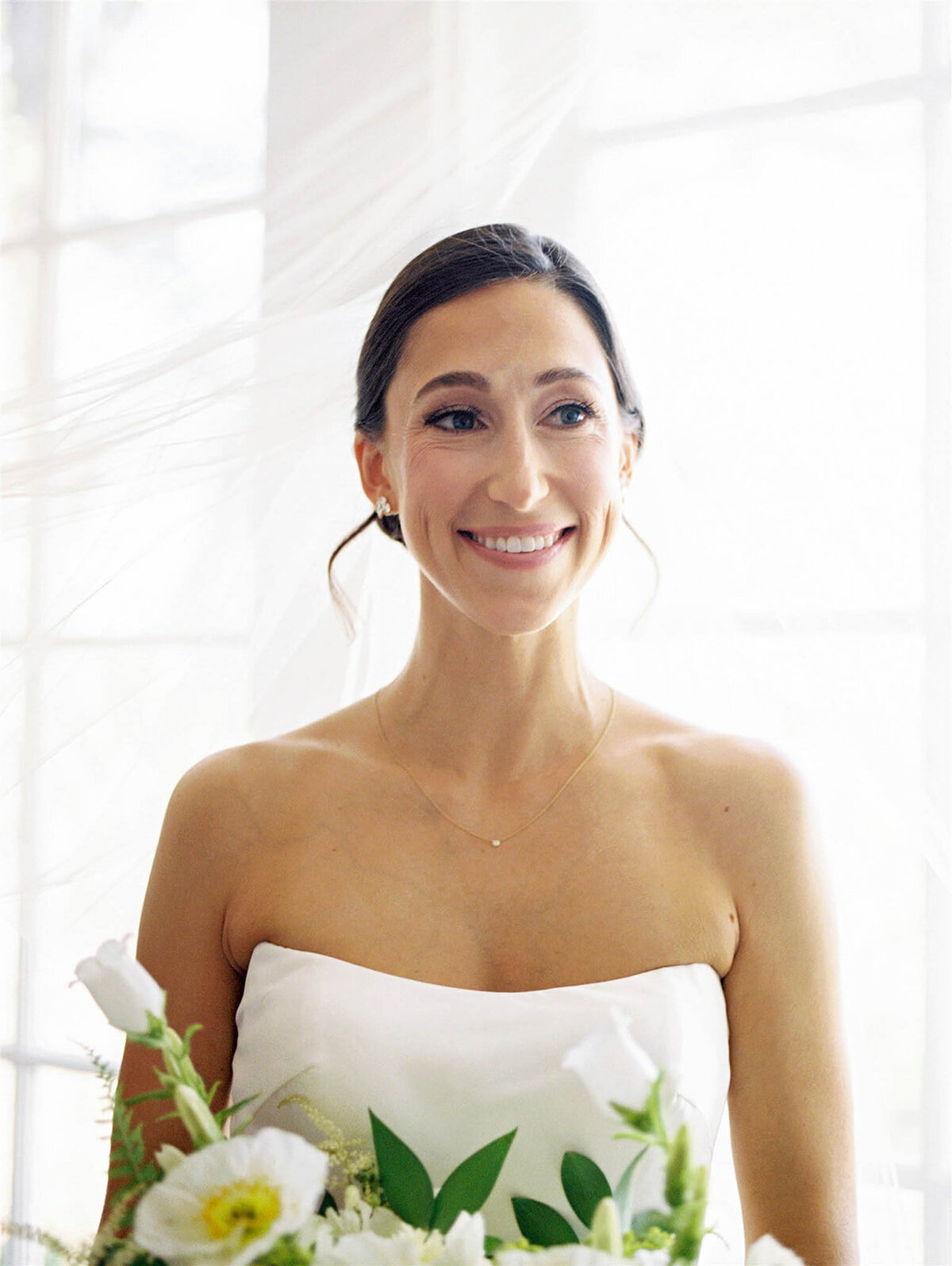 Color image of bride smiling looking at her family.