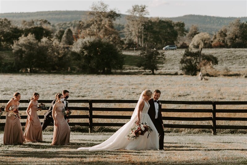 Bride and groom walking  through the meadow