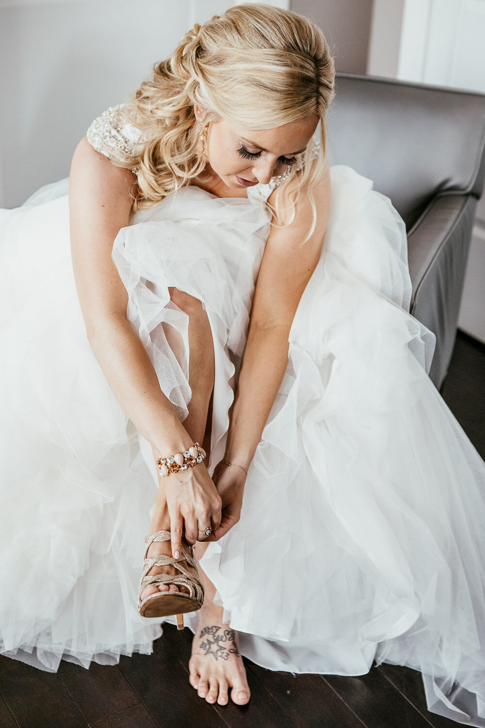 Bride putting on her heels wearing her wedding dress