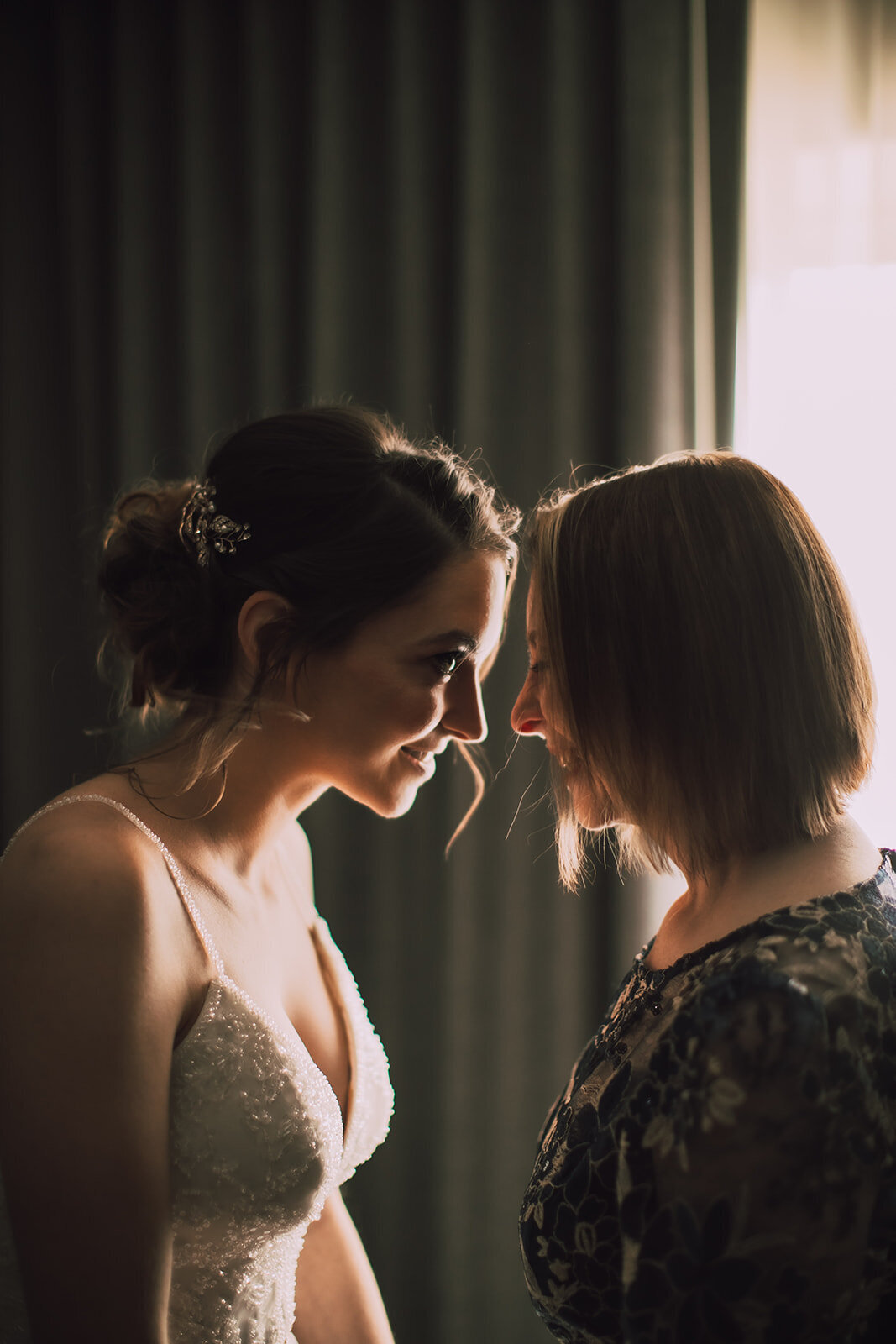Bride and her mother touch foreheads together