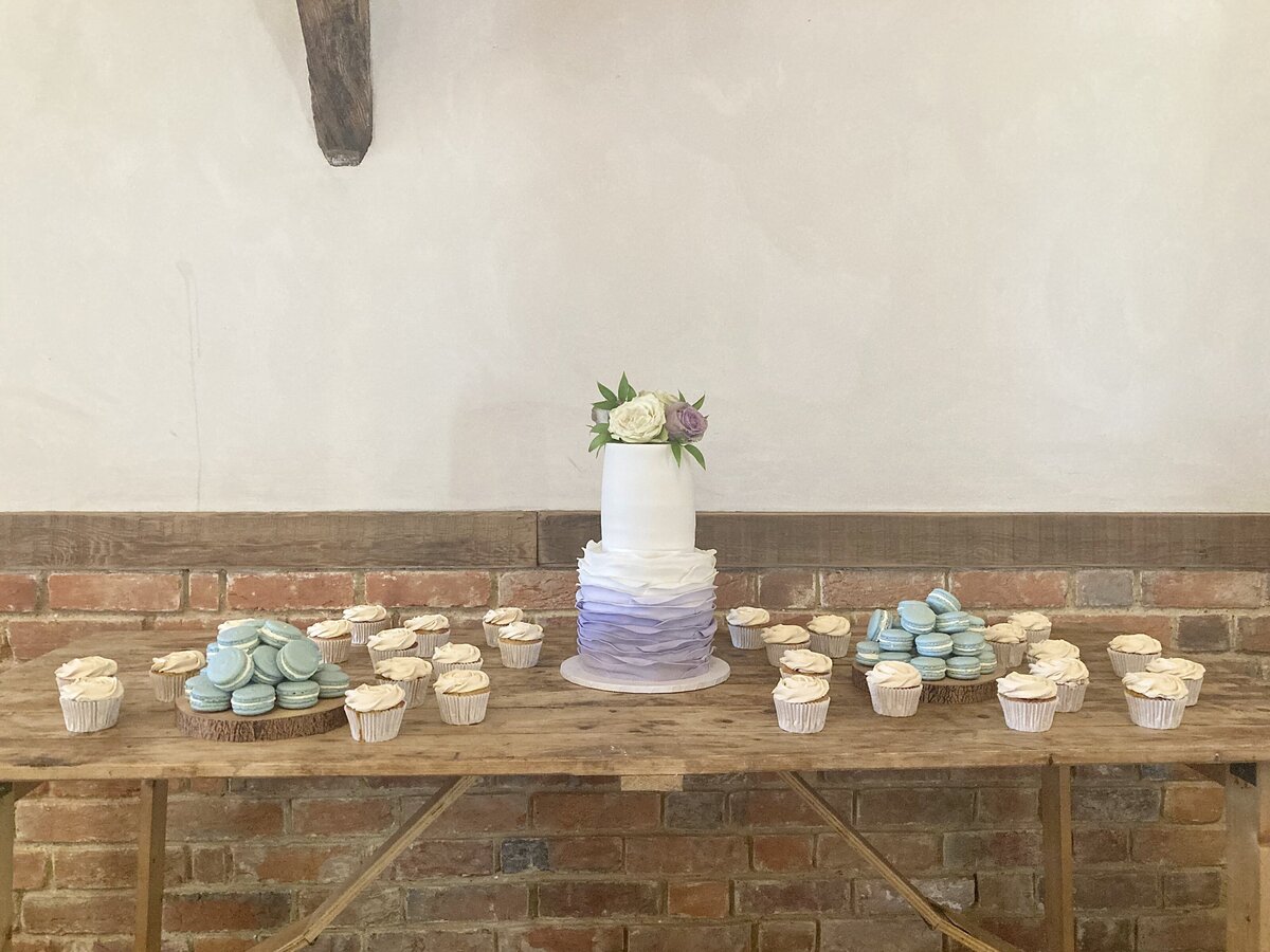 Rustic dessert table with lilac ruffle wedding cake cupcakes and macarons