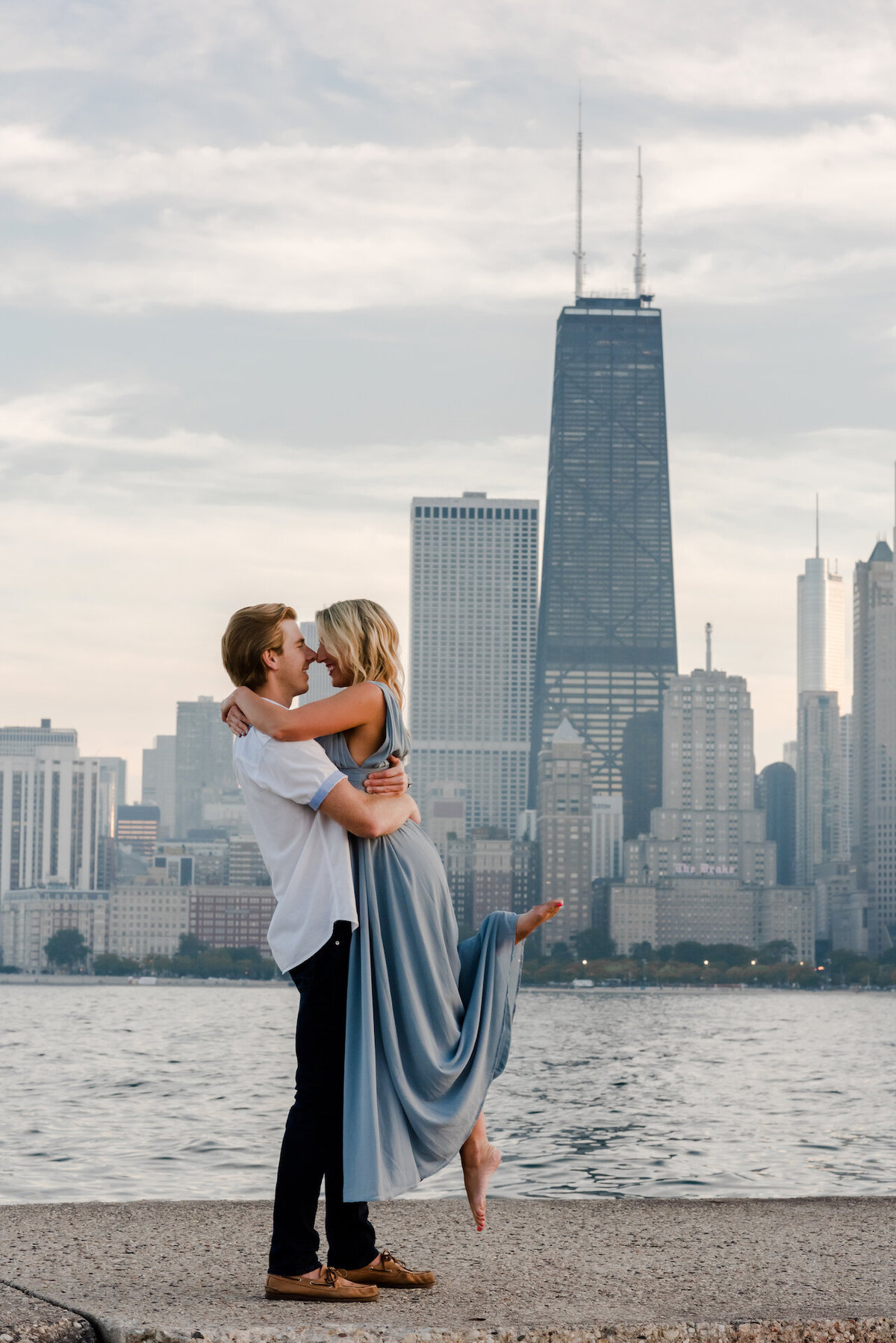 A man picka up a women in front of the Chicago skyline in Chicago