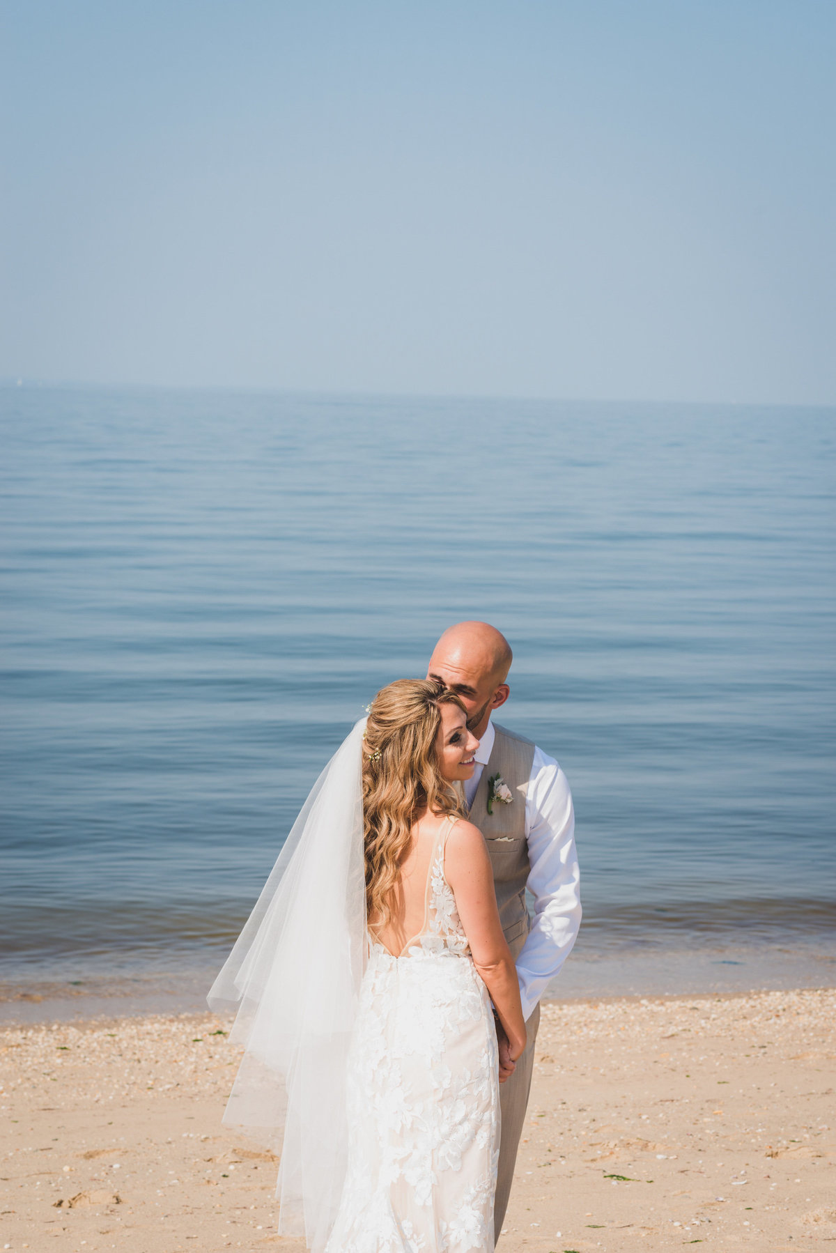 photo of groom and bride on the beach near the water from wedding at Pavilion at Sunken Meadow