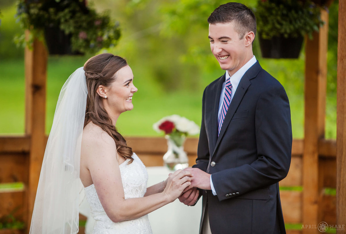 Bride and groom laugh with each other during wedding ceremony at Denver Botanic Gardens Chatfield Farms