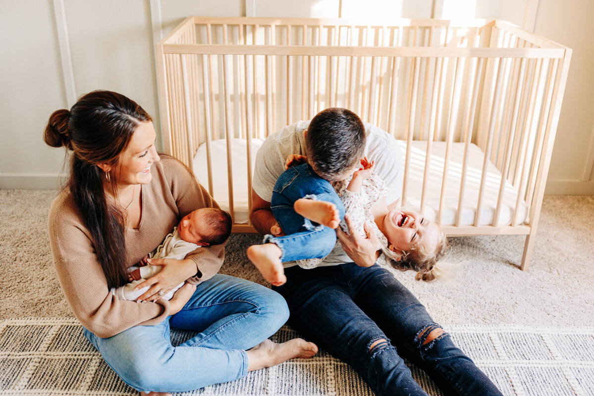 family laughing during their newborn photography session