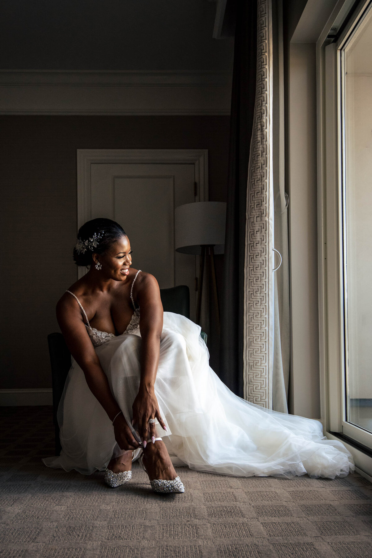 Bride-seated-tying-her-shoe-getting-ready-before-the-ceremony-at-The-Ballantyne-Hotel