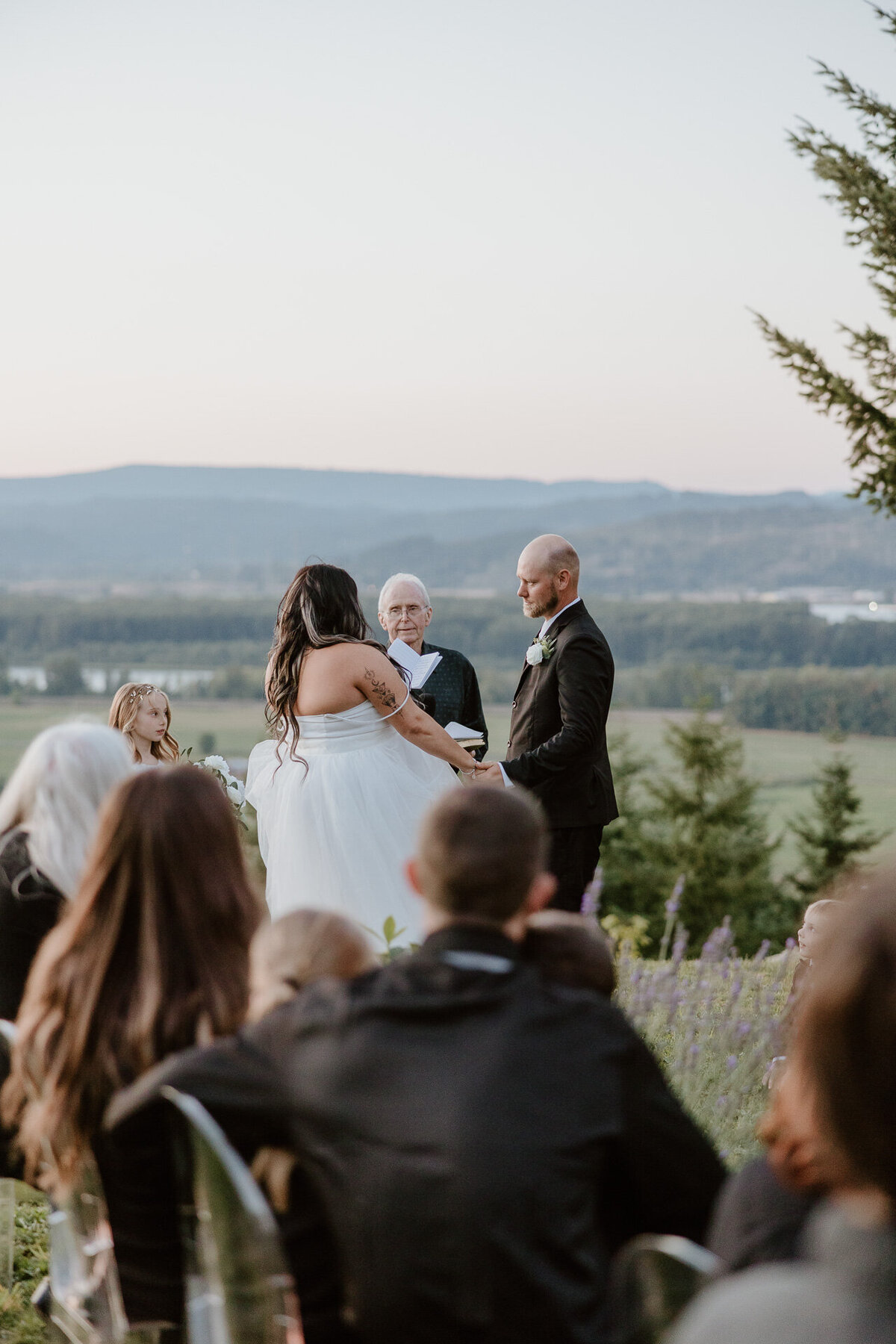 A couple stands at the altar holding hands with their officiant in Rainier, Oregon