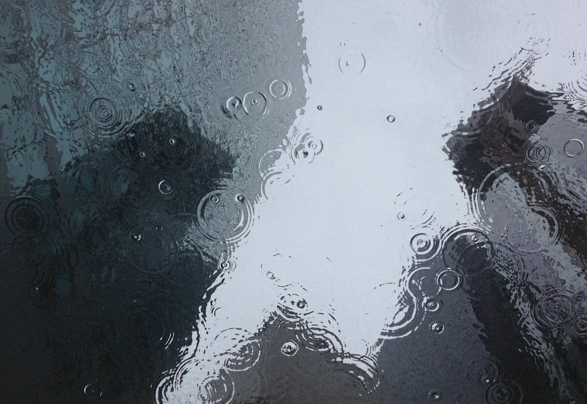Raindrops on a reflective glass surface evoking emotional overwhelm and the need for nervous system relief and support