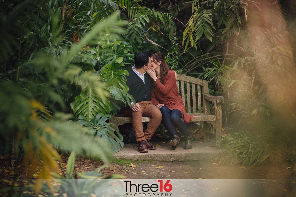 Young couple share a quiet kiss during their engagement photo shoot