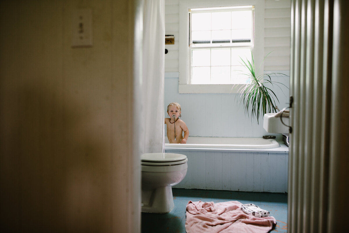 Bathroom scene with toddler in bath at Austin family photo session