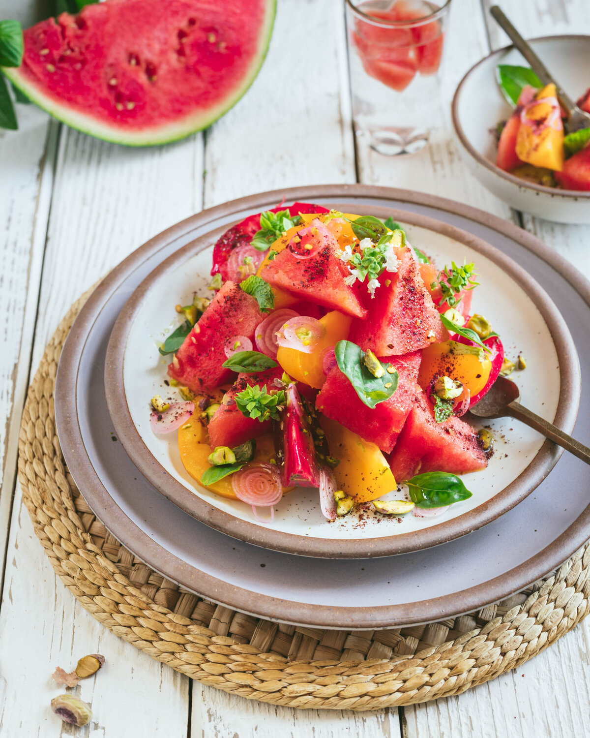 Watermelon and heirloom tomato summer salad with mint, basil and pistachios