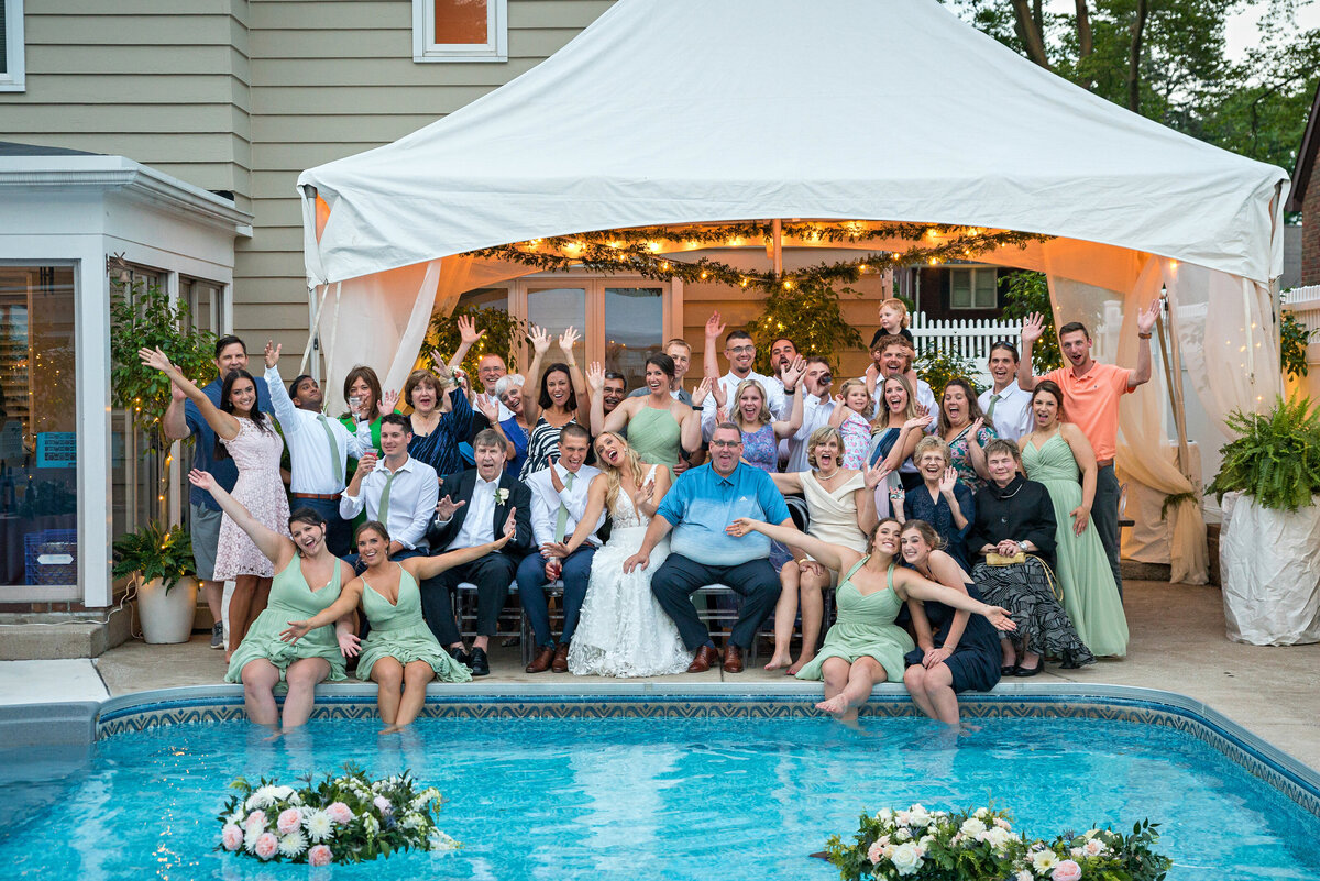 Fun Family portrait at wedding reception by pool.
