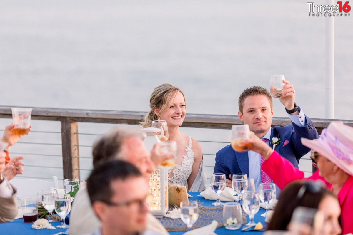 Bride and Groom lift their glasses at the toast