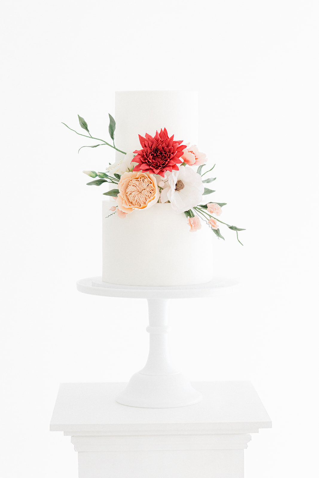 Elegant simple white wedding cake with statement sugar flowers