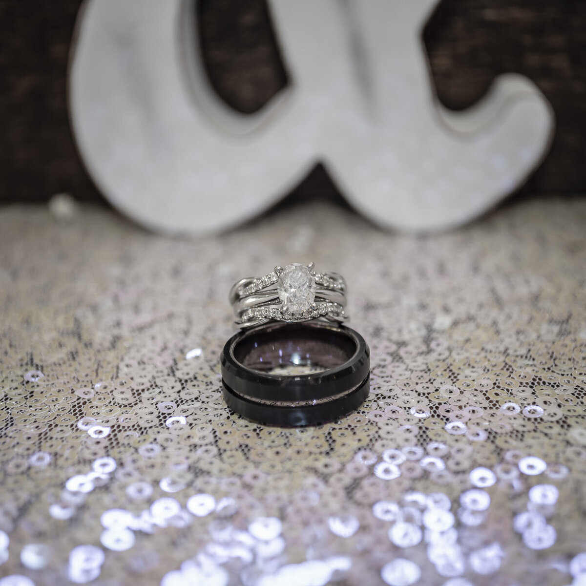A detail photograph of the wedding rings on a glitter table cloth.