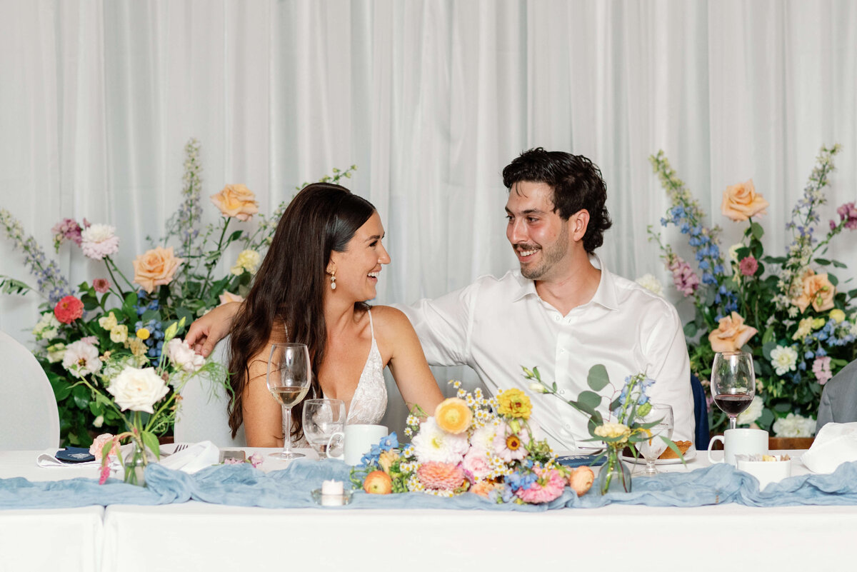 Bride and groom sitting at wedding table at Oak Island Resort wedding, Nova Scotia
