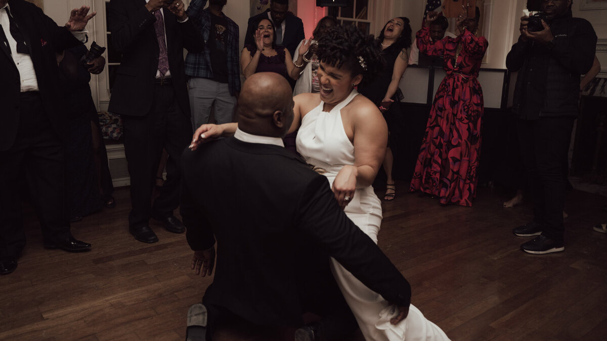 Black couple dance during reception surrounded by guests at River Farm in Alexandria, Virginia.