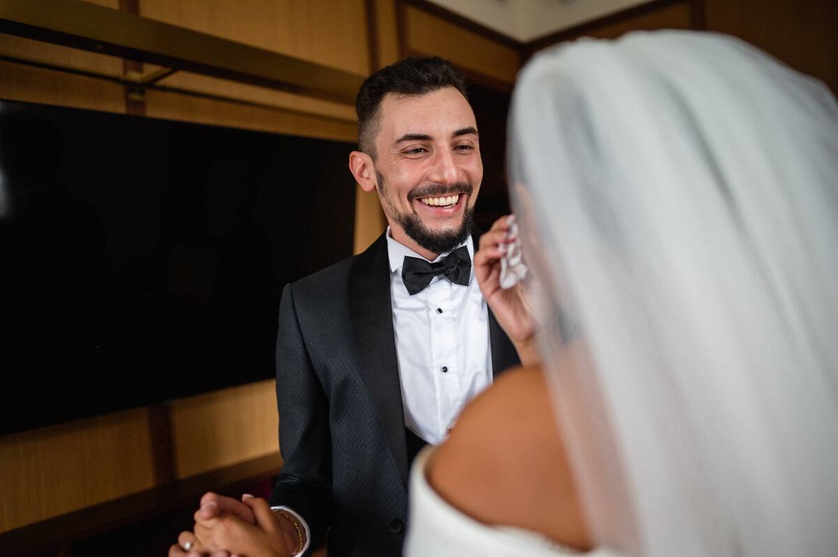 A groom has a first look with his soon to be bride in  their hotel