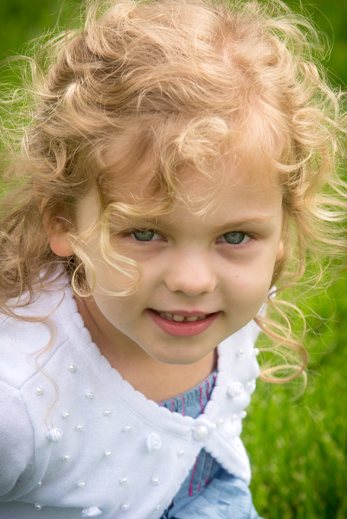 Cute curly haired girl during a family portrait at Lilacia Park in Lombard