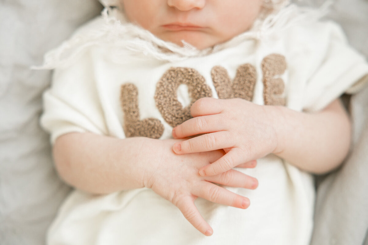 love spelled out on babies shirt, for newborn session in houston with Ally's PHotography.