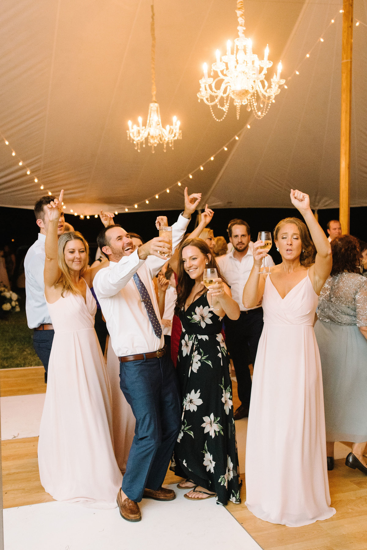 Wedding Guests dancing on Birch Wood and White checkered Dance Floor under Sailcloth Tent with Cafe Lighting and Crystal Chandeliers