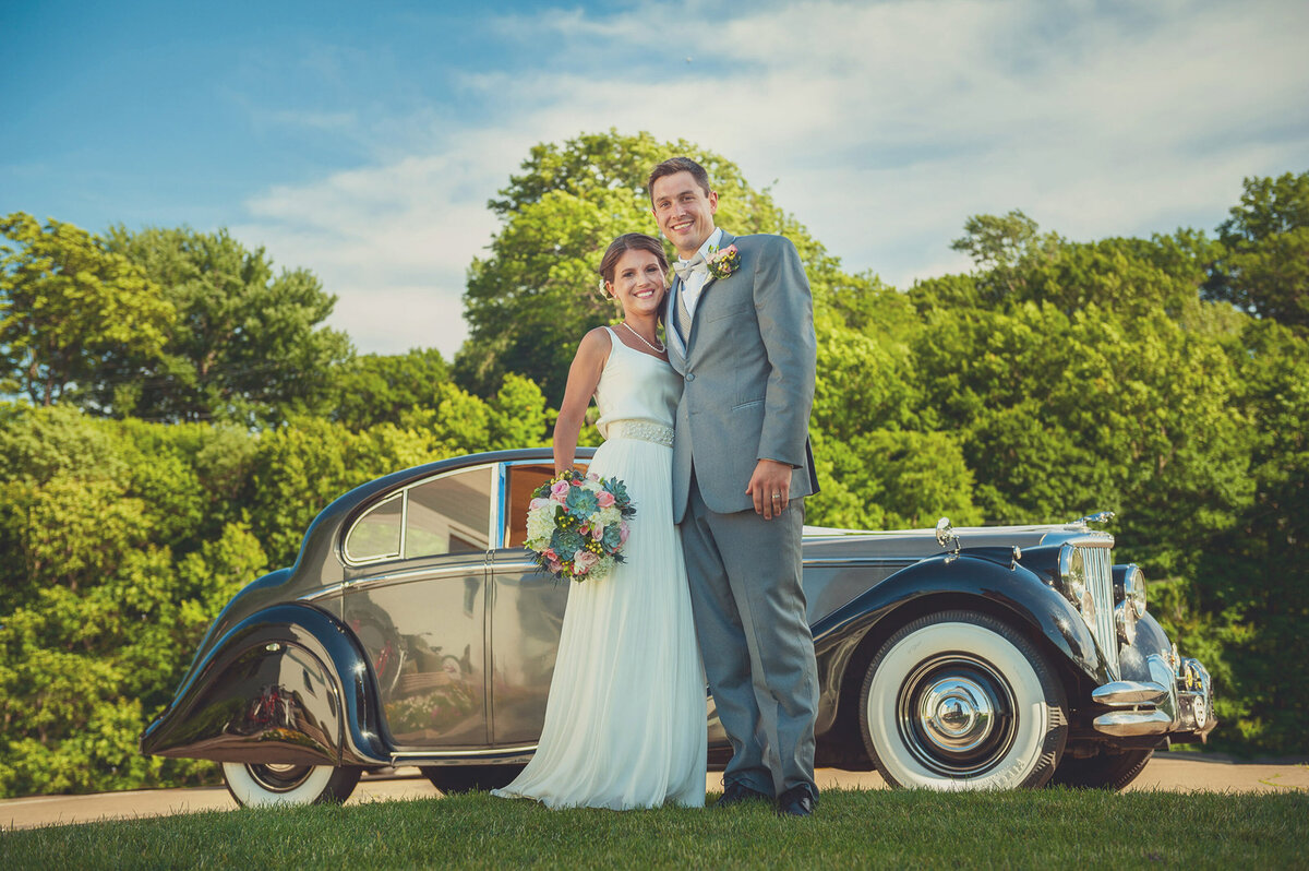 Wedding couple in front of classic car.