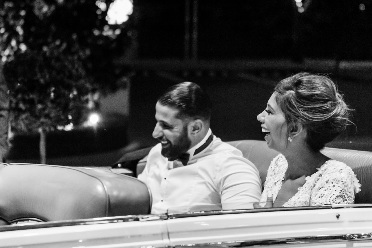 Bride-and-groom-sitting-in-their-vintage-wedding-exit-car-after-reception