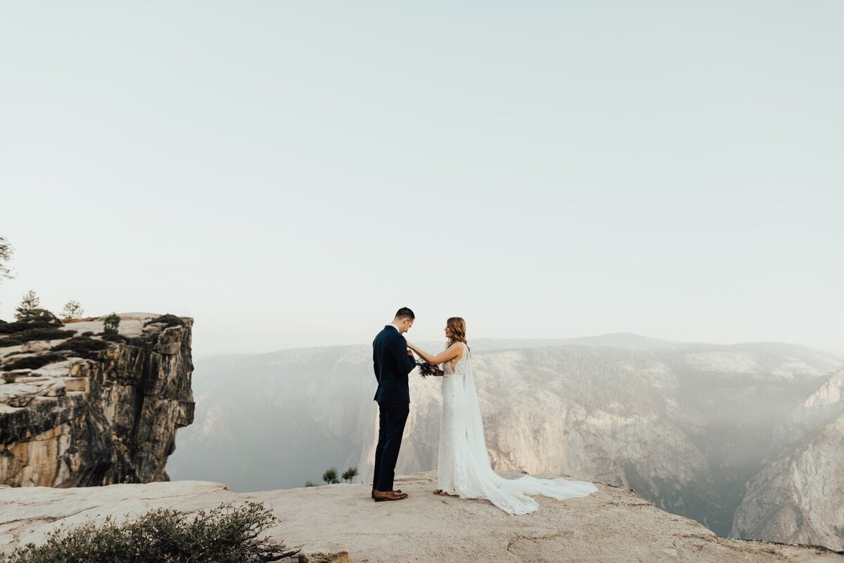 Bride and groom standing on a mountain ledge for their elopement