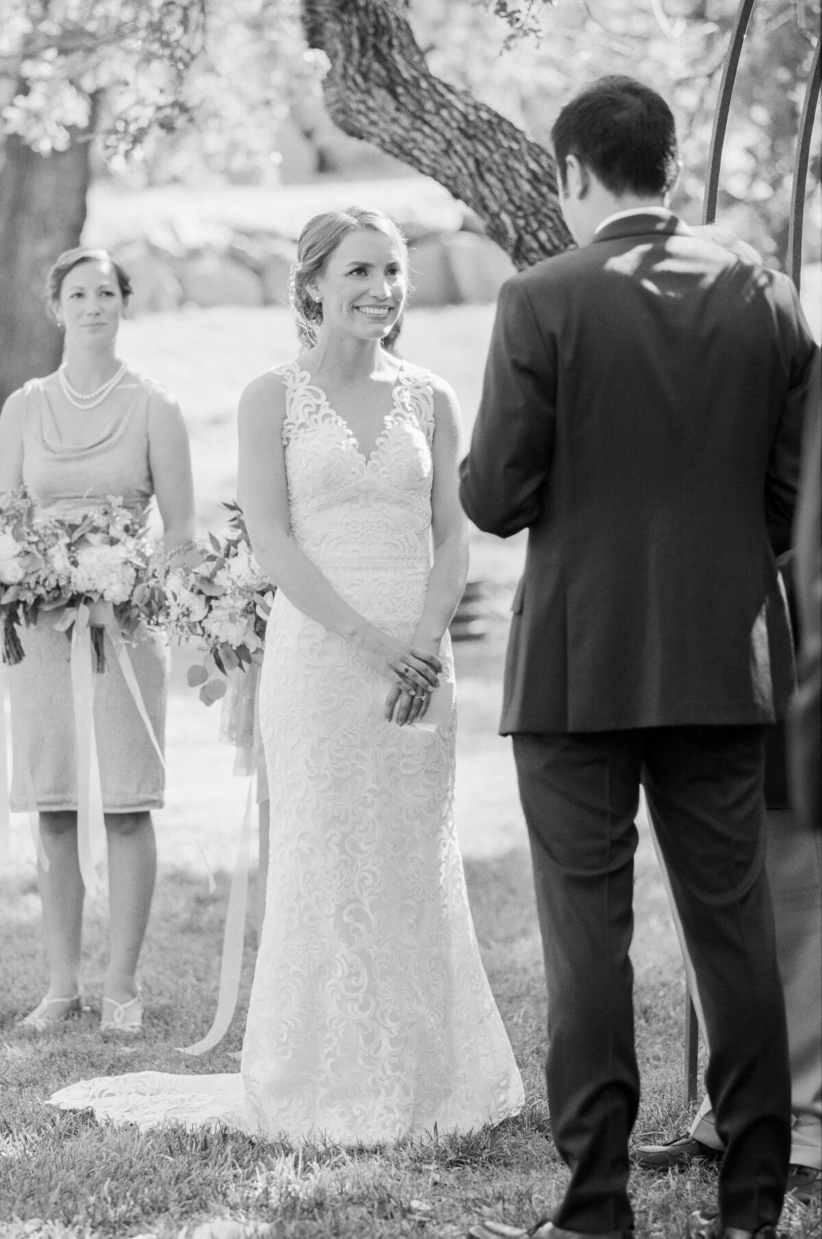 Bride looks at her husband-to-be as he reads his vows.