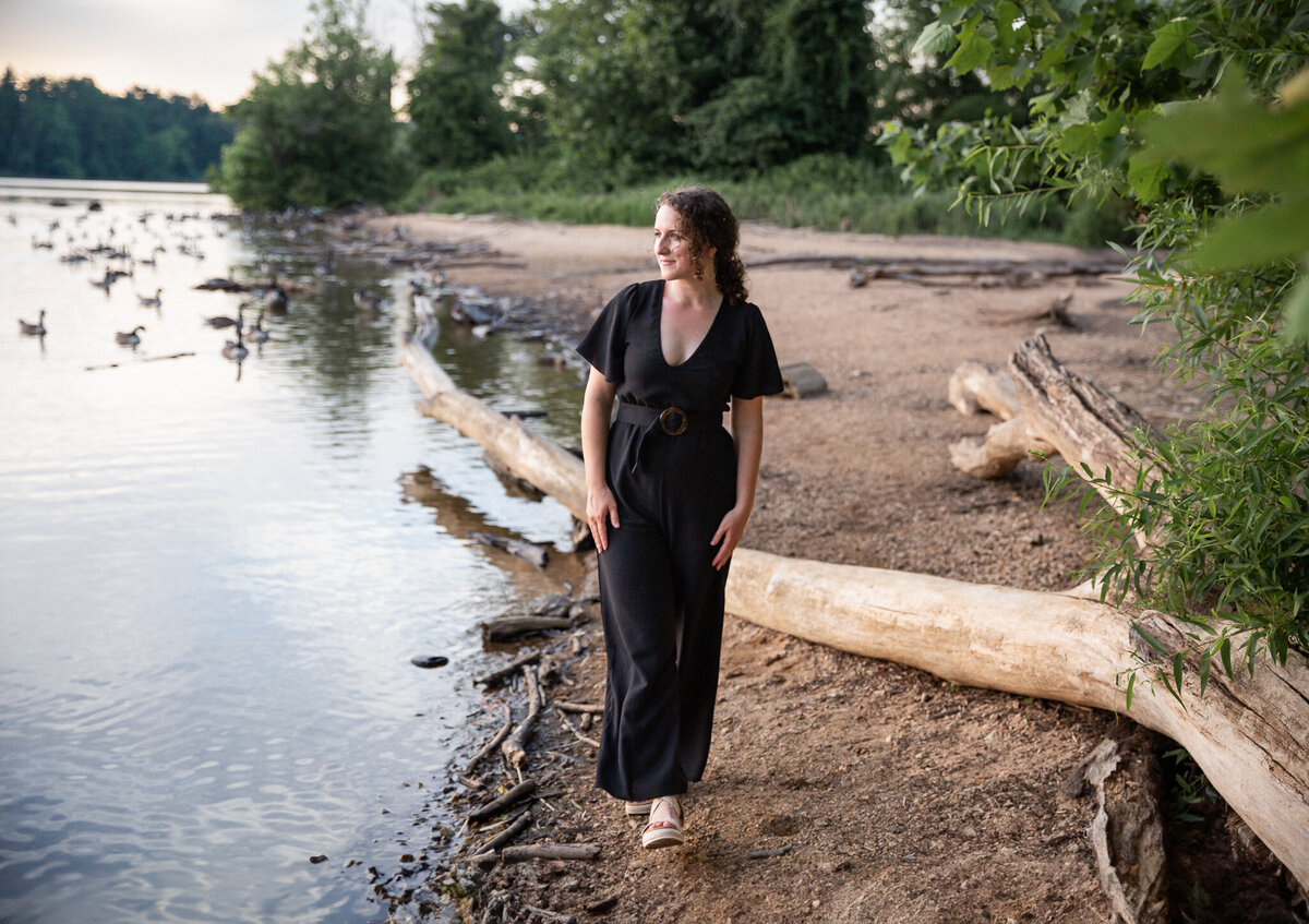 A writer walks along beach in Baltimore, Maryland during branding photoshoot.