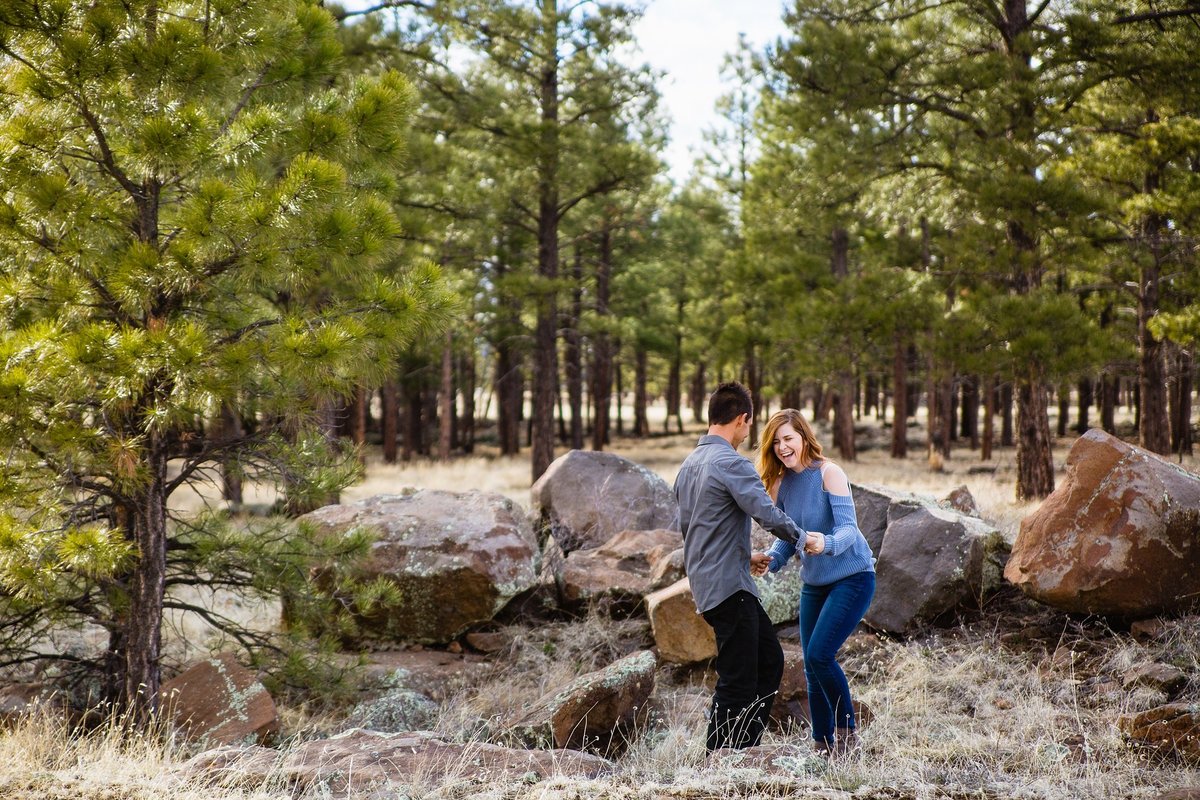 Couple laughing and having fun together during their Buffalo Park engagement session by adventure engagement photographer PMA Photography.