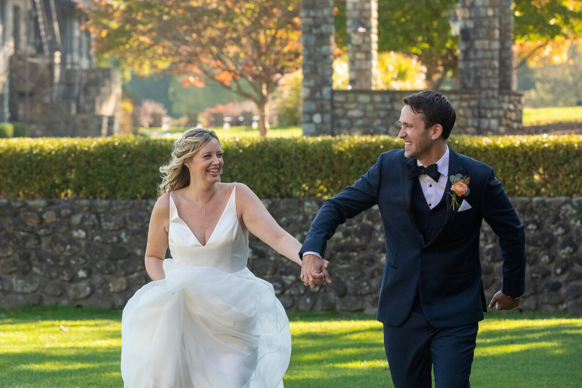 Birde and groom hold hands and laugh as they run Paramount Country club wedding photographer Milestone Images