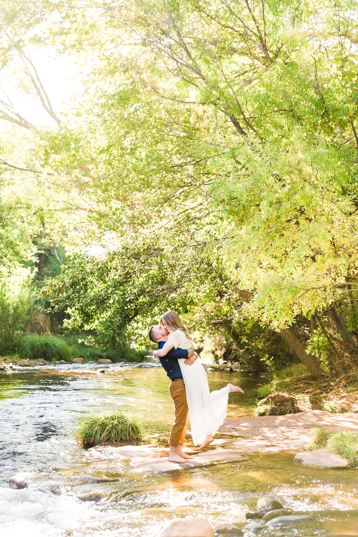 engaged couple posing together for engagement photo in Sedona creek