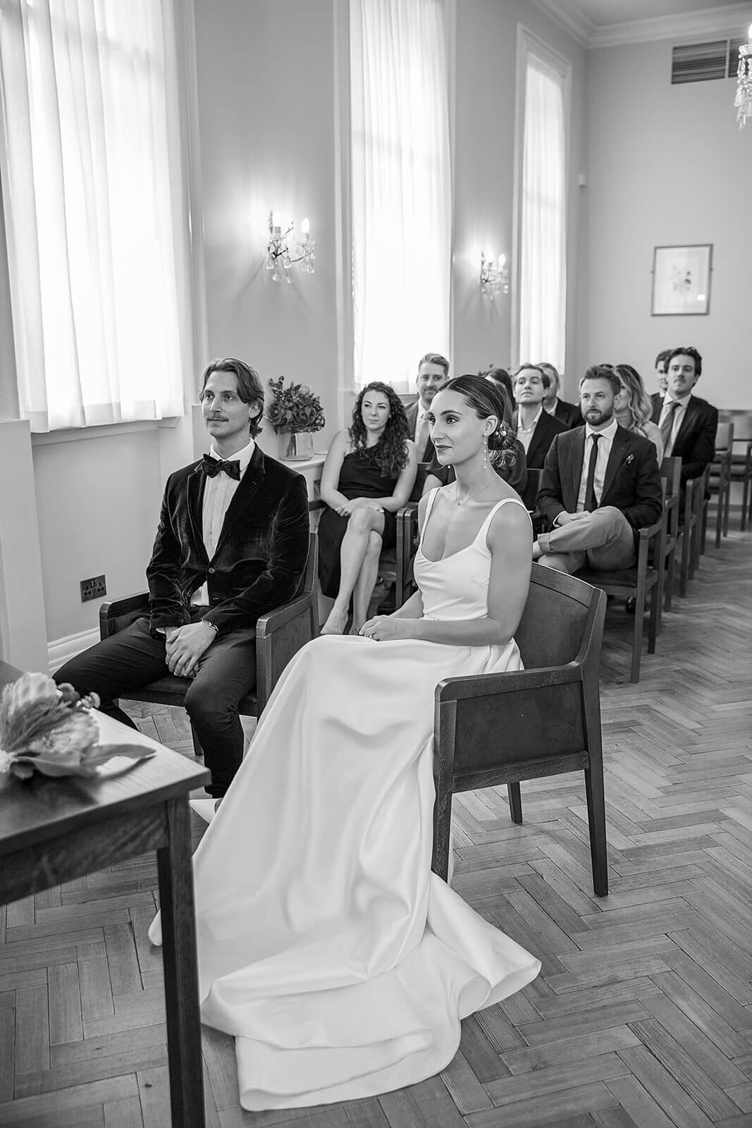 Bride and groom sitting during ceremony in Brydon Room