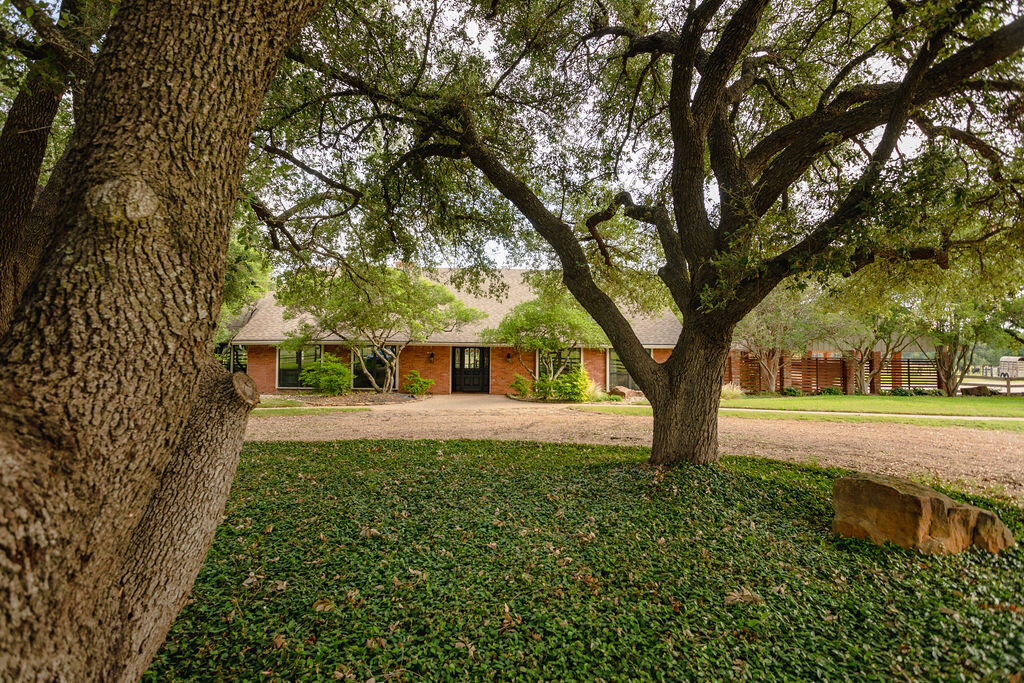 Large circle driveway in front of this 5-bedroom, 4-bathroom vacation rental house for 16+ guests with pool, free wifi, guesthouse and game room just 20 minutes away from downtown Waco, TX.