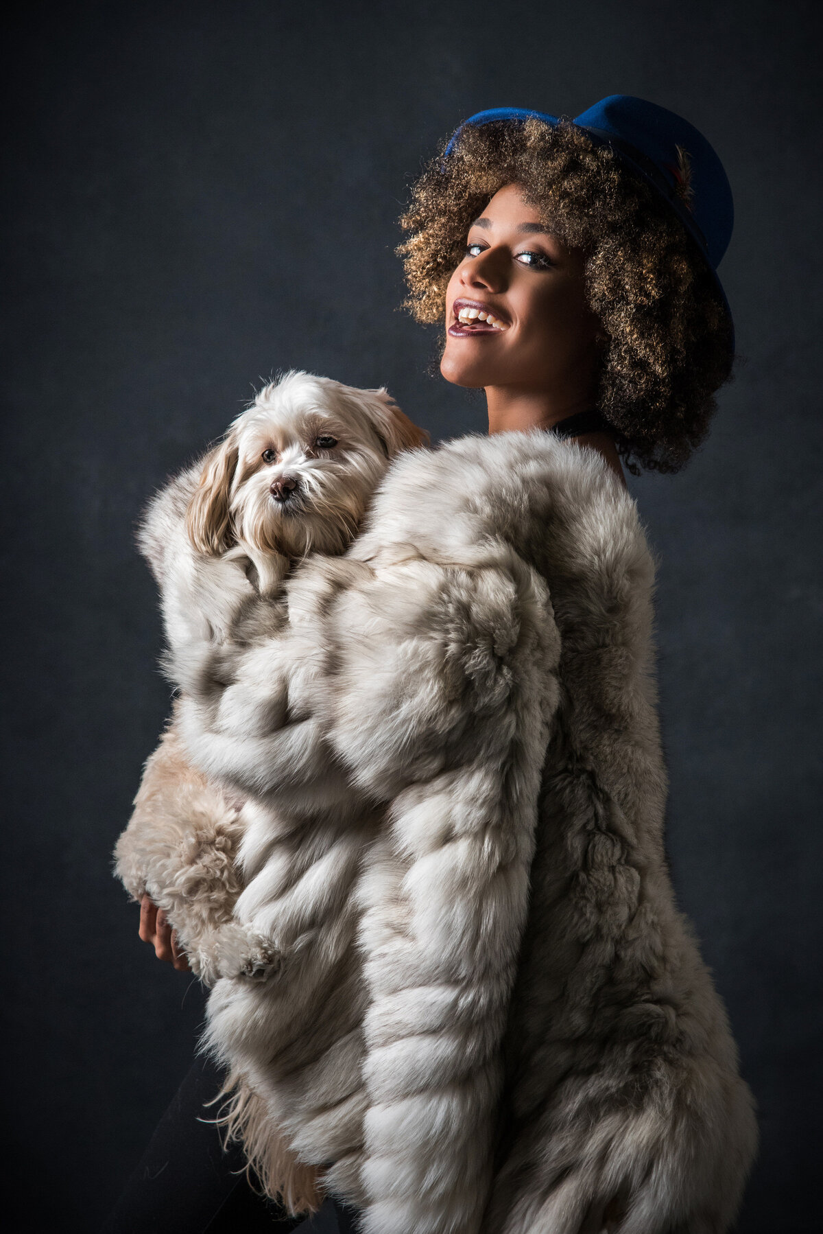 A woman in a fur coat holding a dog.
