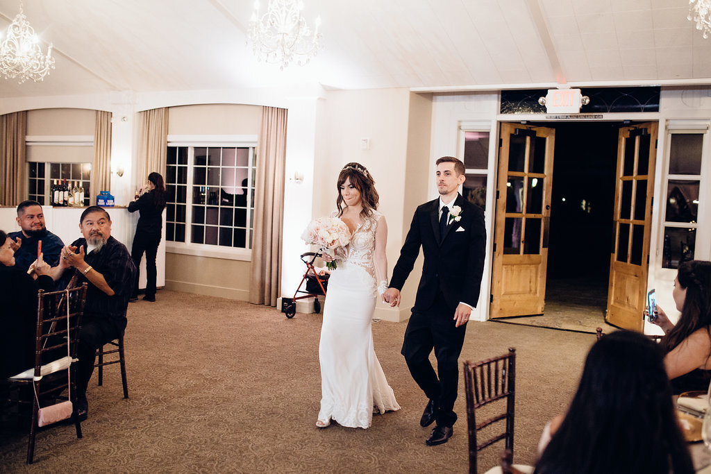 Wedding Photograph Of Bride And Groom Holding Hands While Walking Inside The Reception Hall Los Angeles