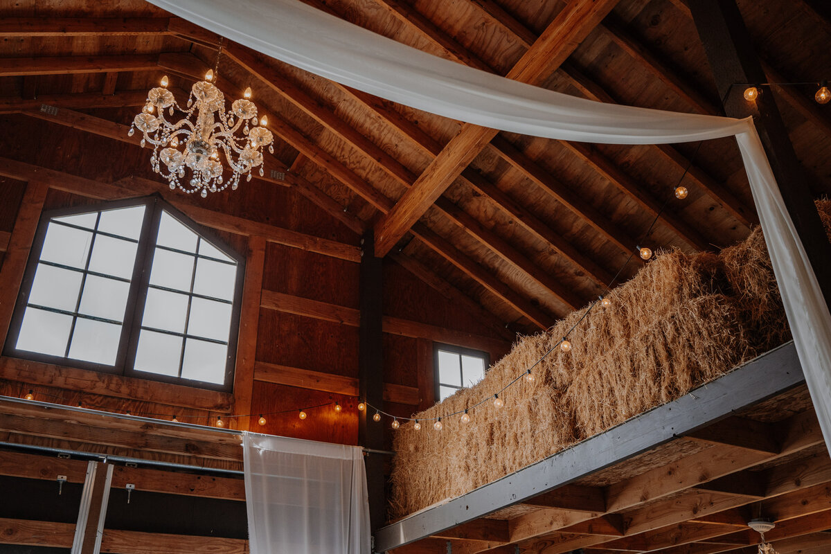 Bales of hay in the loft of a barn decorated with wedding decorations