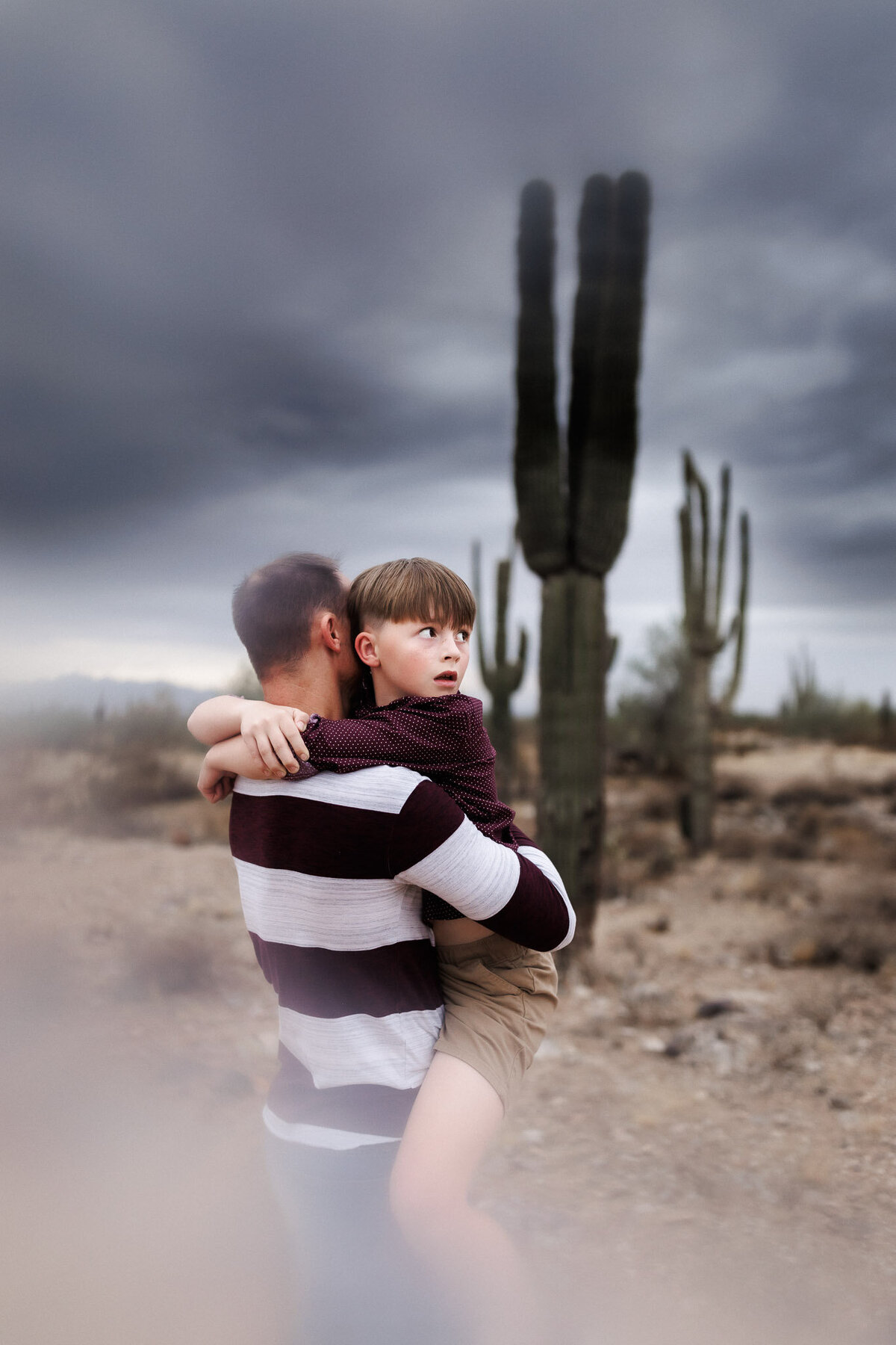 dad holding son in the dessert with cactus