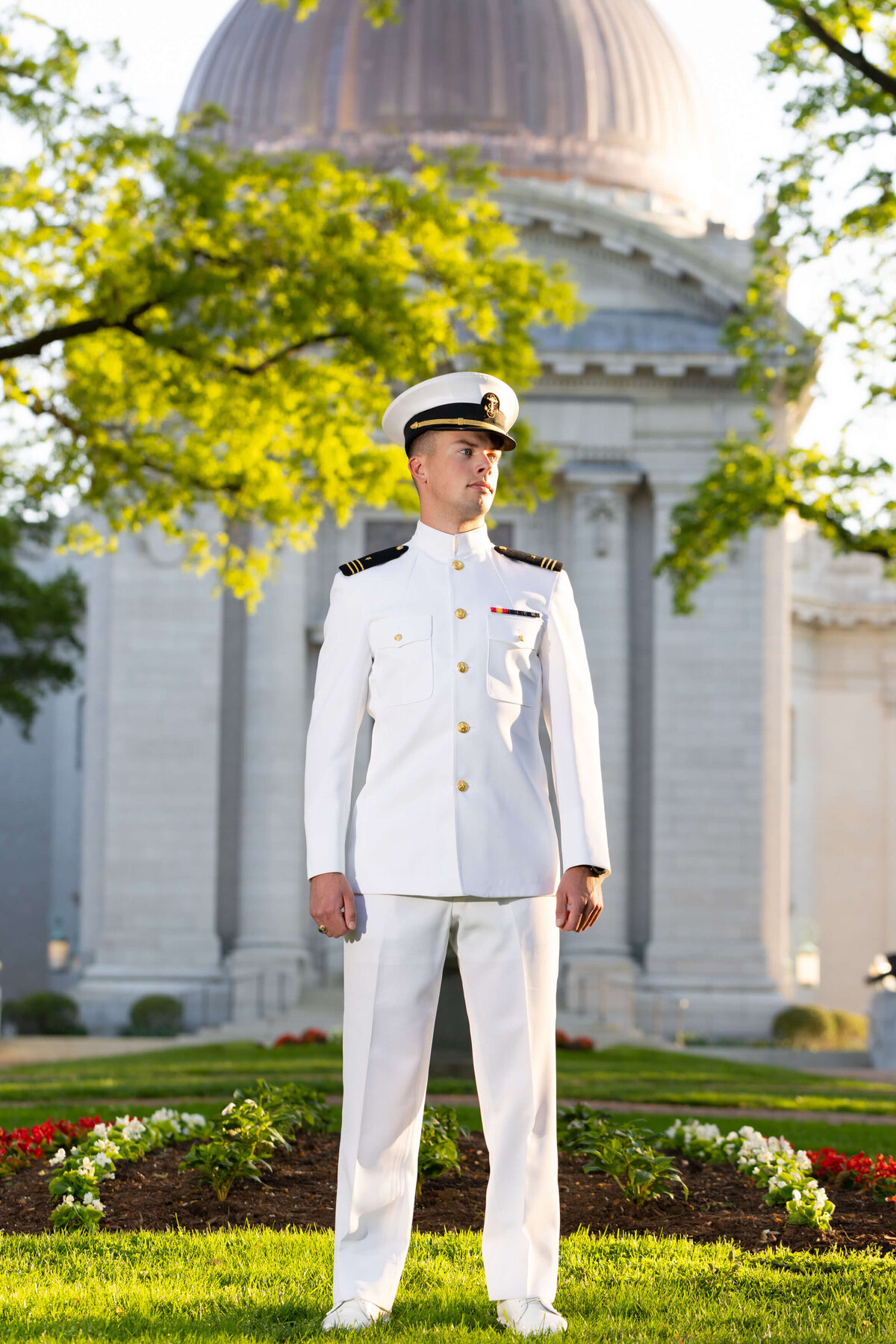 Senior Portrait in Annapolis Maryland of Midshipman in whites at Naval Academy Chapel dome with flowers.