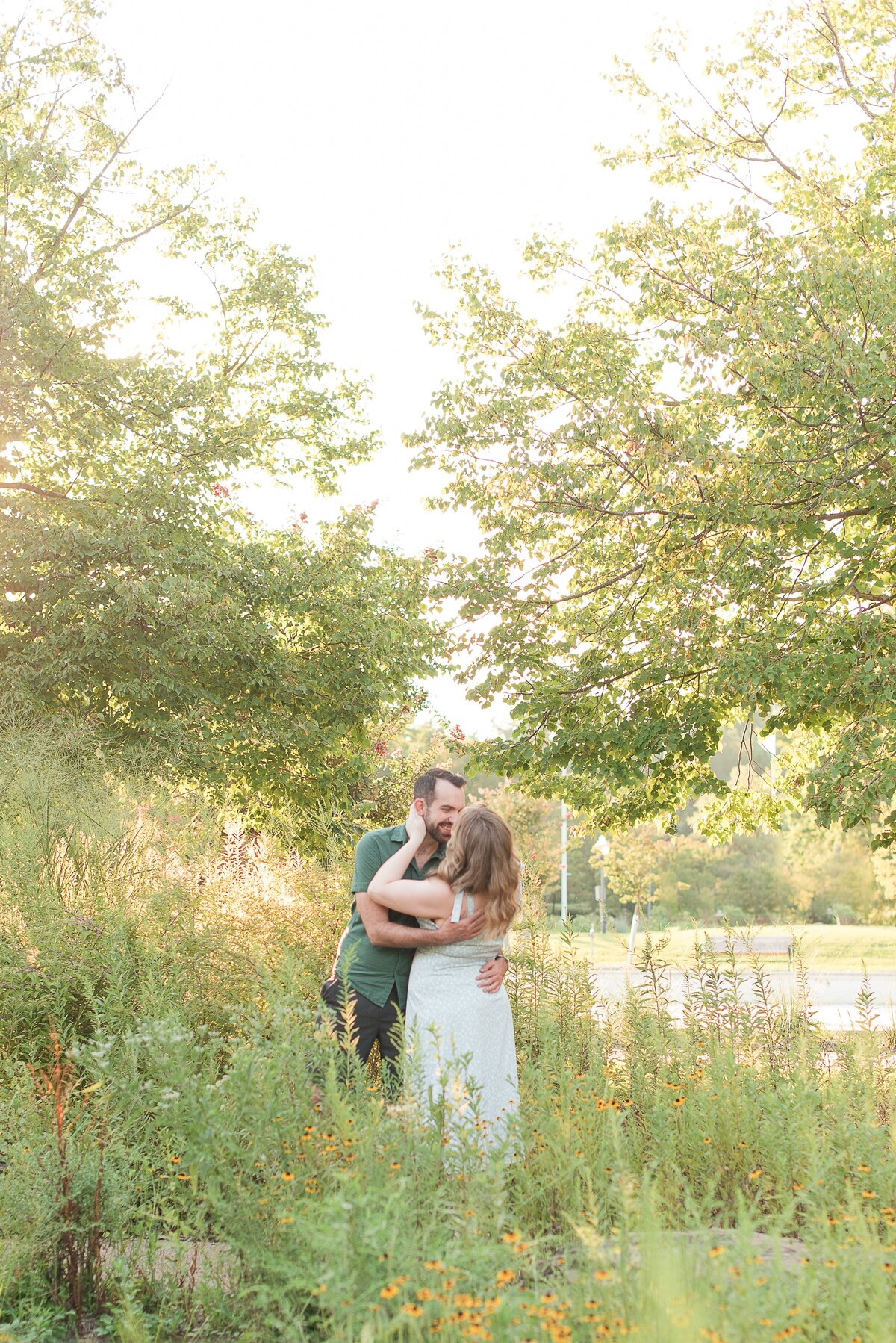 couple kissing surrounded bu greenery