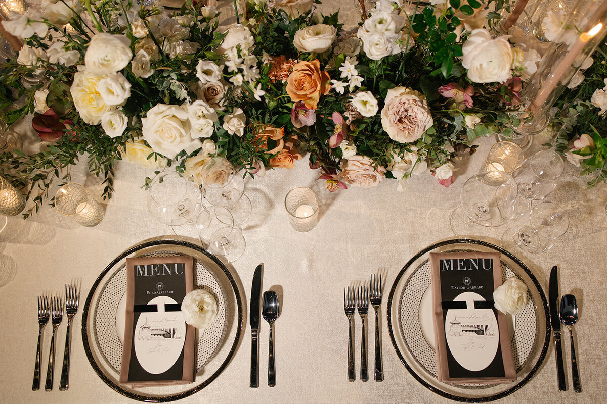 placesetting with menu cards, white roses and pastel taper candles