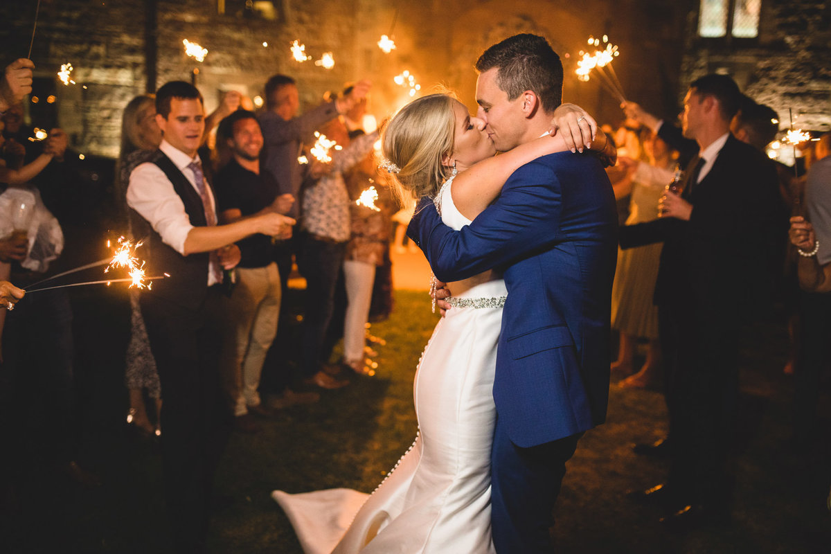 bride and groom kissing during sparklers at peckforton castle