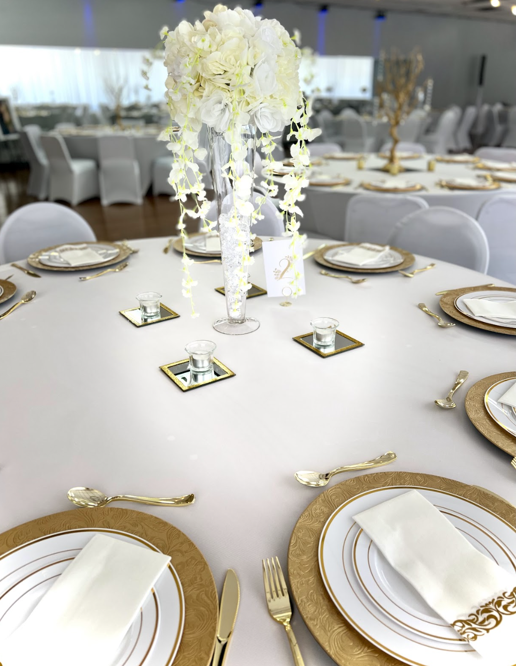 Exquisite wedding reception guest table with a stunning white floral centerpiece - Enhancing the elegance and beauty of the celebration