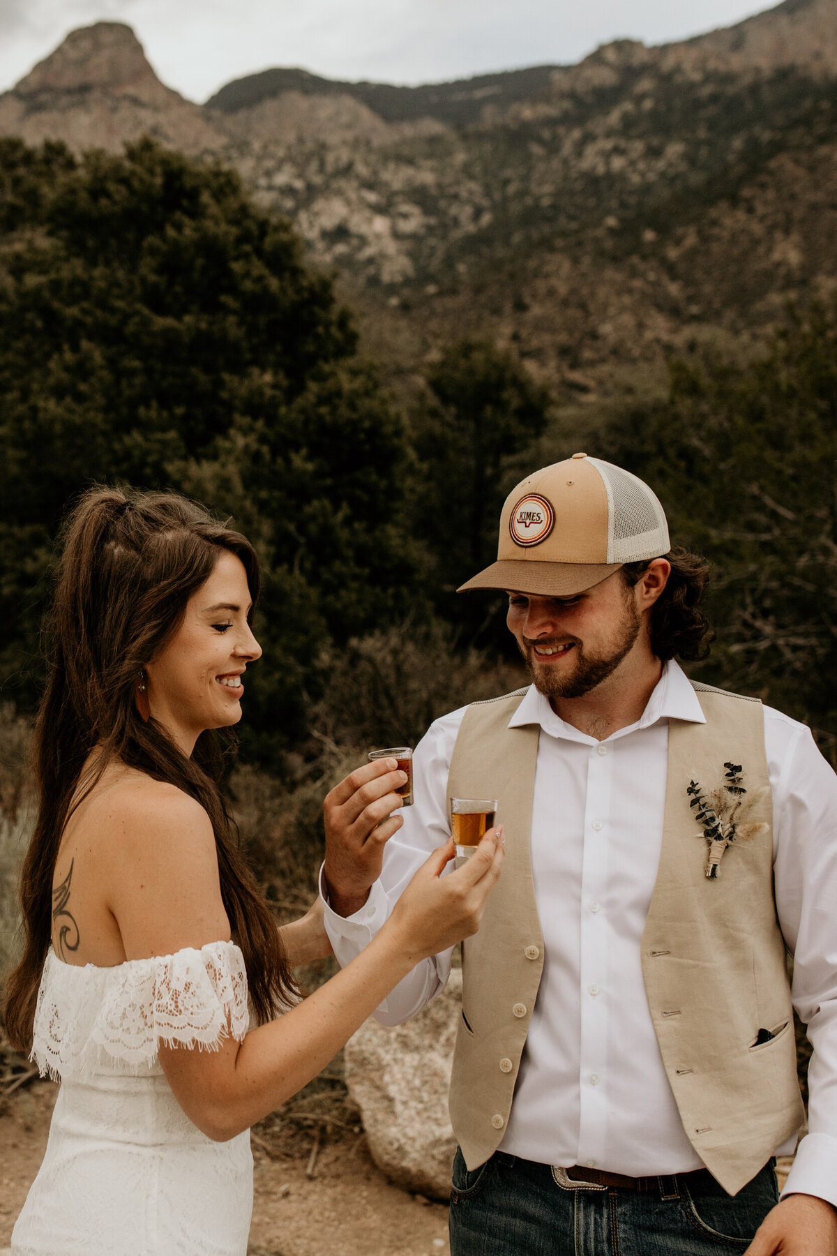 newlyweds taking a shot of whiskey  at the Sandia mountain foothills