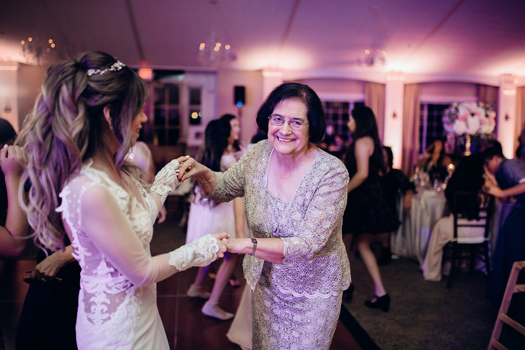 Wedding Photograph Of Bride In White Dress Dancing With A Smiling Older Woman  Los Angeles