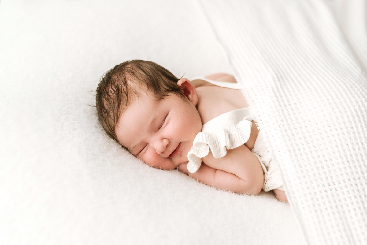 baby girl smiling at a newborn photoshoot in BillingshurstÅÇ